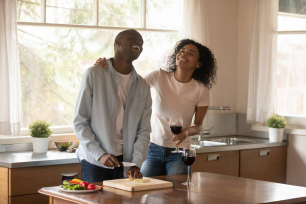 istock Romantic african couple enjoy date while cooking in the kitchen 1163367380