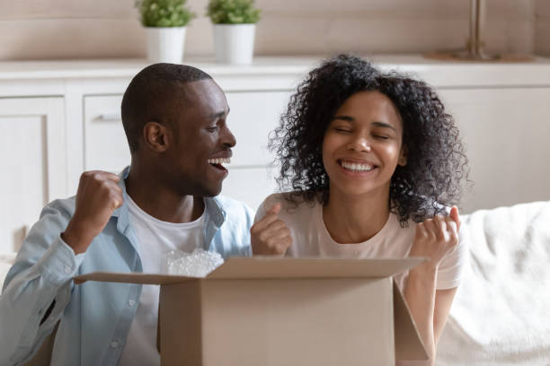 istock African spouses sit on couch with cardboard box feels happy 1163367409