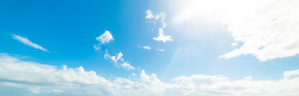 istock Sun shining over a blue sky with white clouds 1163368862
