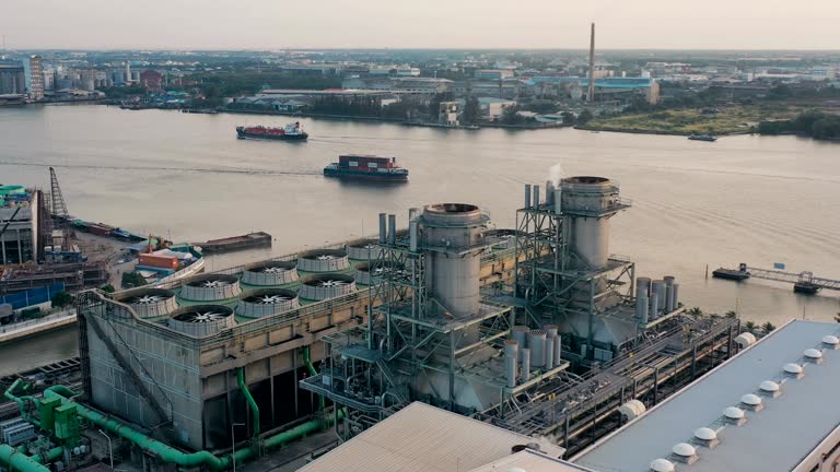 Aerial view of combined cycle power plant or fuel gas powerplant with plume or steam at cooling tower at night