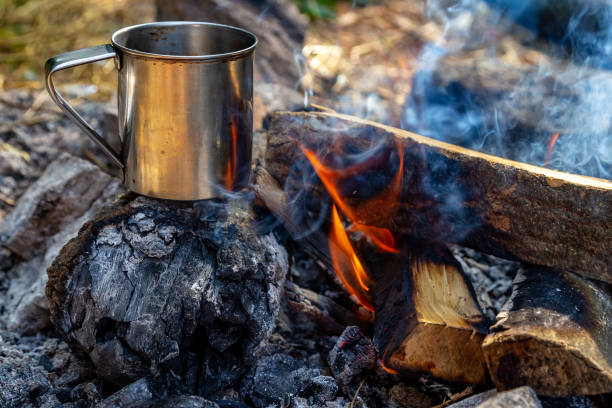 istock steel cup on an open fire in nature. Cooking on fire. Camping in summer. 1163370437
