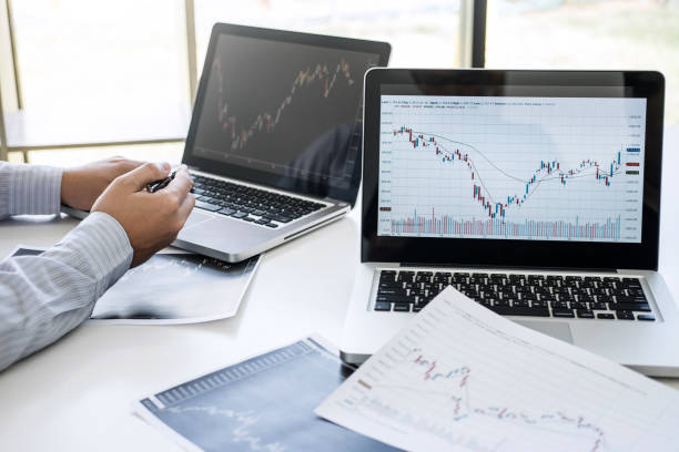 istock Business team two colleagues working with computer, laptop, discussing and analysis graph stock market trading with stock chart data, financial and investment concept 1163371887