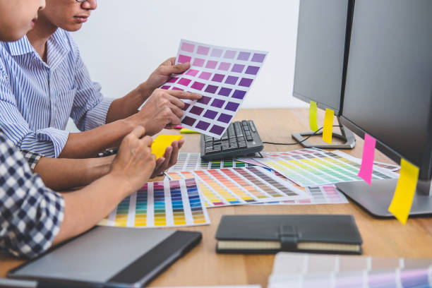 istock Two colleagues creative graphic designer working on color selection and drawing on graphics tablet at workplace, Color swatch samples chart for selection coloring 1163371920