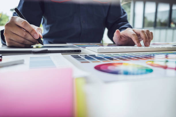 istock Image of male creative graphic designer working on color selection and drawing on graphics tablet at workplace with work tools and accessories 1163371996