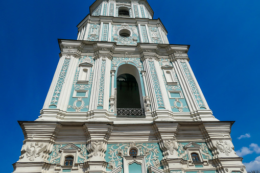 Close-up on the middle part of the bell tower of St Sophia's Cathedral in Kiev, Ukraine. The tower is painted blue and white and richly decorated on each side. Tall and immense construction