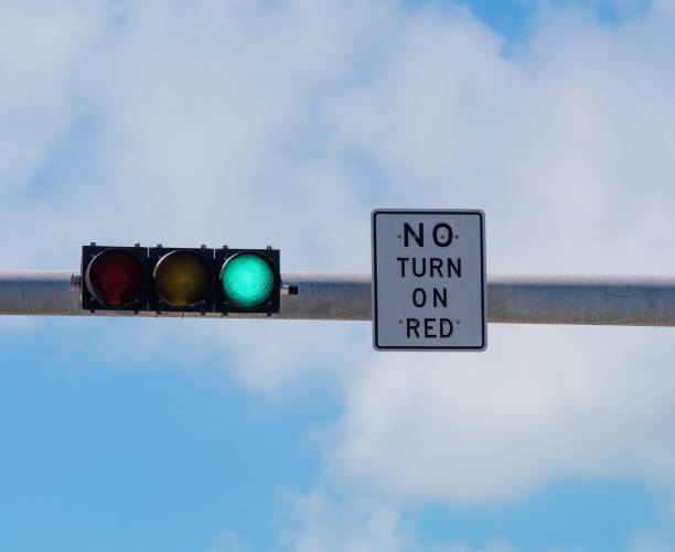 istock Traffic light and No Turn on Red sign under a cloudy sky 1163374956