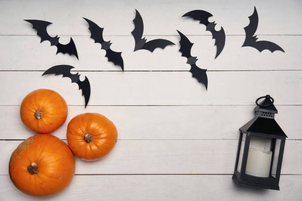 istock Halloween card with pumpkins, black bats and black lantern on white 1163375064