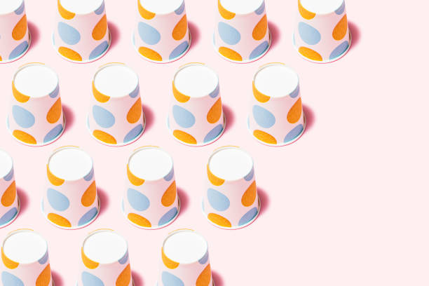 istock Yellow and blue polka dot paper cups on pink background 1163378986