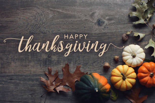 счастливый текст приветствия благодарения с тыквами падения, сквош и листьями на темном фоне древесины - thanksgiving стоковые фото и изображения