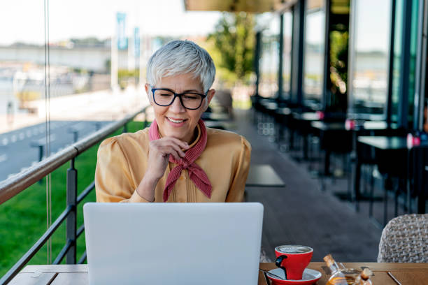 istock Mature business woman at cafe using laptop 1163380544