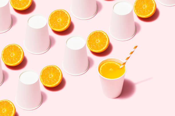 istock Orange juice and white paper cups flat lay on pink background 1163380904