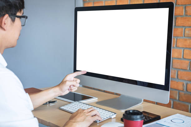 istock Image of Young man working in front of the computer laptop looking at screen with a clean white screen and blank space for text and hand typing information on keyboard in modern workspace 1163383852