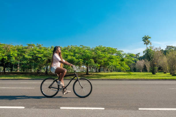 Beautiful black brazilian Woman riding a bicycle stock photo