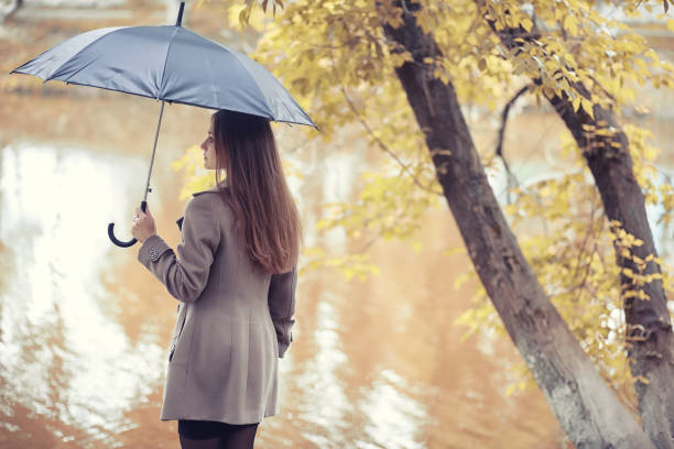 istock Young girl in a coat in autumn  park 1163388523