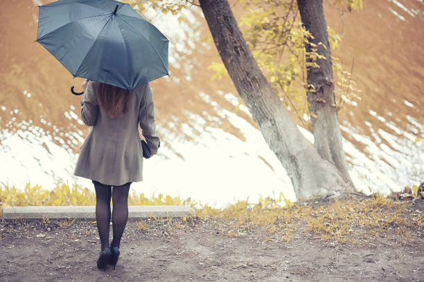 istock Young girl in a coat in autumn  park 1163388537