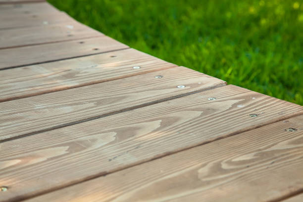 istock Wooden table in diagonal on the image with blurred summer green background 1163388662