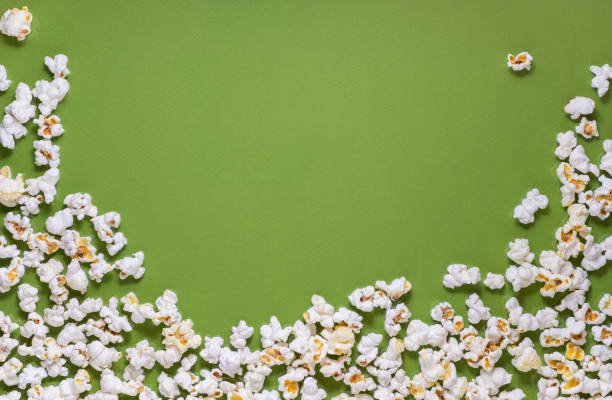 istock White tasty popcorn on a green background. Popcorn pattern on green background. Top view. Copyspace for your text. 1163388744