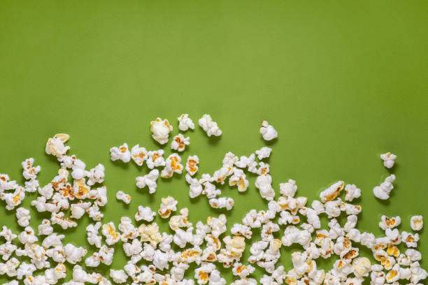 istock White tasty popcorn on a green background. Popcorn pattern on green background. Top view. Copyspace for your text. 1163388747