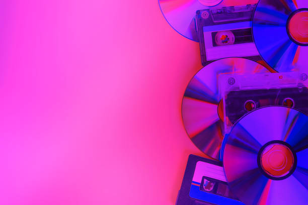 istock CD disks and audio cassettes on pink neon background. Minimalism. 1163390132