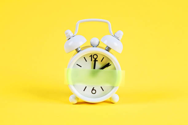 istock White alarm clock yellow pastel background. Blank sticky note on clock. Space copy. Minimal concept. 1163390232