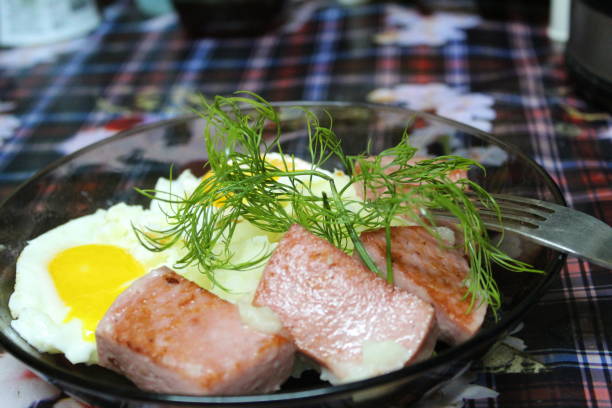 mashed potatoes with fried sausage and fried egg in a plate