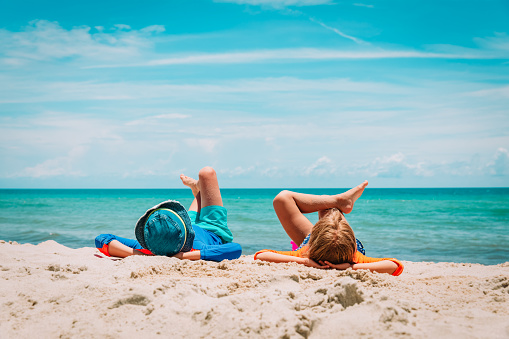 little boy and girl relax on tropical beach vacation
