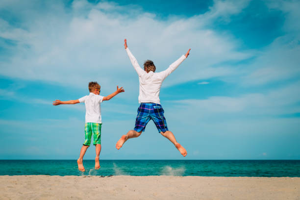 istock father and son have fun jump at tropical beach 1163399821