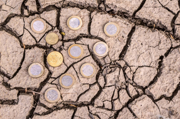 istock Euro coins on dry ground. 1163402693