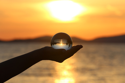 Glass ball reflection of sea sunset.