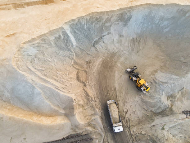 istock Big heavy wheel loader loading sand into dump truck in sand pit. Heavy industrial machinery concept 1163409539