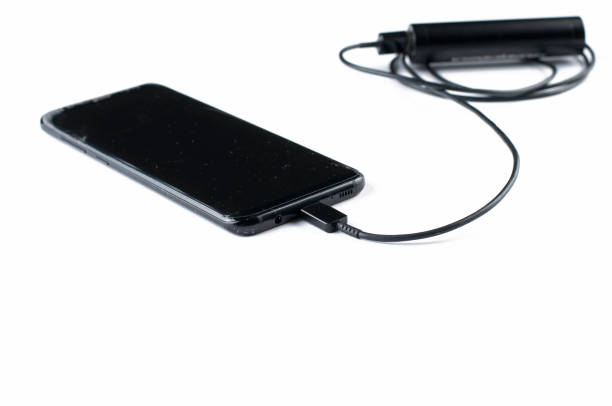 istock Black mobile phone and charger isolated on white background.Copy space. 1163413787