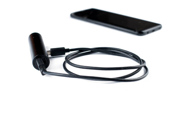 istock Black mobile phone and charger isolated on white background.Copy space. 1163413830