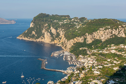 High angle view of the coastline and Marina Grande, the main harbor in the Island of Capri in the Tyrrhenian Sea in Italy. Boats are floating next to the coast.
