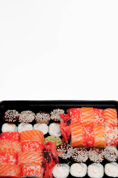 istock Big sushi set ib black plastic box on white background, top view close up, copy space 1163414167