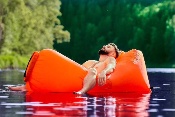 istock Tourist sleeping inside air sofa in water. 1163416028