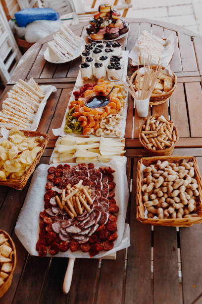 istock Typical spanish tapas concept. Concept include variety slices chorizo, salami, cheese, chips, bread, sandwiches, donuts, yogurt, fruits fondue tangerine, banana, kiwi, blueberries, strawberries on a wooden table 1163417004