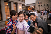 浴衣の若い友人が日本の伝統的な祭りを訪れ、自撮り写真を撮る