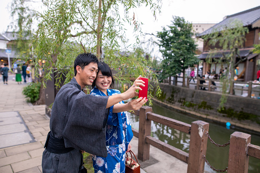 Young couple in yukata taking selfie picture in local Japanese village