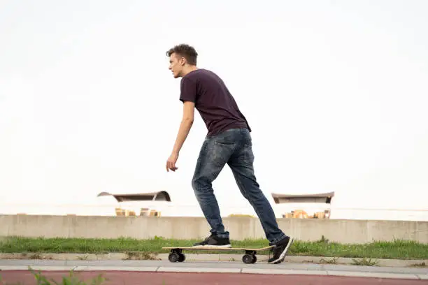 Photo of Side view teenager on a long board