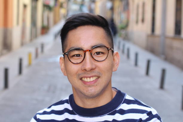 istock Cute Asian man smiling outdoors 1163424241