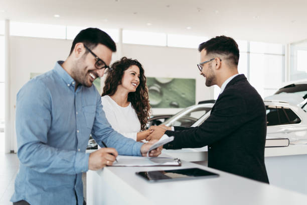 istock Attractive couple buying new car 1163425138