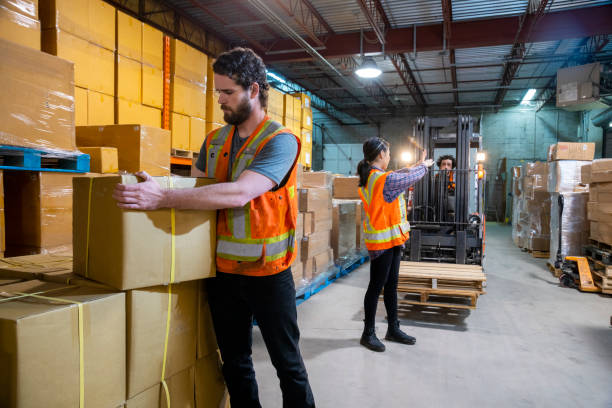 istock An industrial warehouse workplace safety topic. A coworker stops a forklift proceeding to allow a fellow worker to work safely 1163427654