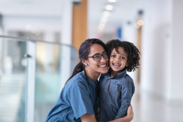 istock Female doctor hugging her toddler patient 1163427871