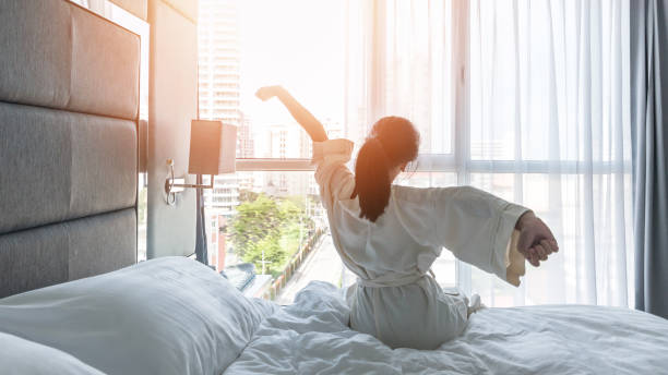 Hotel room comfort with good sleep easy relaxation lifestyle of Asian girl on bed have a nice day morning waking up, taking some rest, lazily relaxing in guest bedroom in city hotel comodidad de la habitación del hotel con buen sueño fácil estilo de vida de la chica asiática en la cama tienen un buen día por la mañana despertando, tomando un poco de descanso, relajante perezosamente en el dormitorio de invitados en el hotel de l