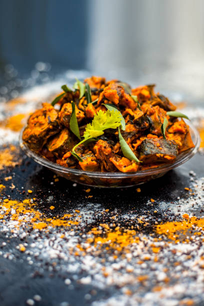 Famous Indian & Gujarati snack dish in a glass plate on wooden surface i.e. Patra or paatra consisting of mainly Colocasia esculenta or arbi ke pan or elephant ear leaves and spices. Vertical shot. famoso plato de aperitivos indian & gujarati en un plato de vidrio sobre superficie de madera, es decir, patra o paatra que consiste principalmente en colocasia esculenta o arbi ke pan o hojas de oreja de elefante y especias. disparo vertical.