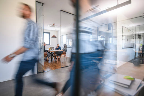istock Business Colleagues in Motion Past Office Conference Room 1163429480