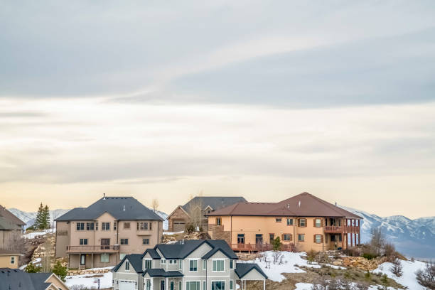 istock Multi storey homes built on a snow covered slope against cloudy sky in winter 1163434173