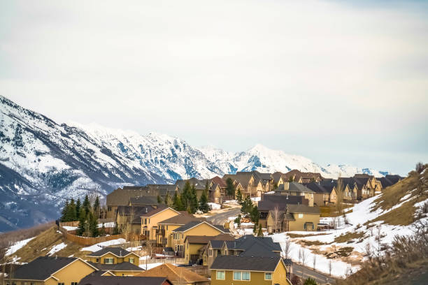 istock Homes along a paved mountain road against bright cloudy sky in winter 1163434848