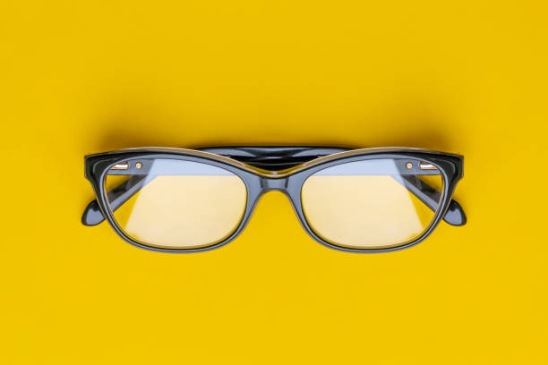 istock Glasses with transparent lenses isolated on yellow background. Front view with copy space 1163435637