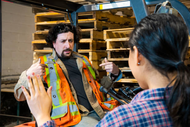 istock An industrial warehouse workplace safety topic. A manager discusses an issue with a forklift driver. 1163440391